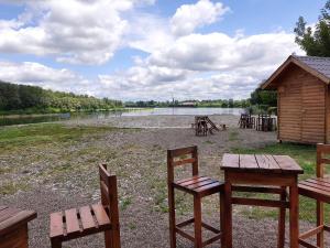 a group of chairs and tables in front of a lake at Apartman Čeliković centar Šamca, parking, balkon, WiFi in Bosanski Šamac