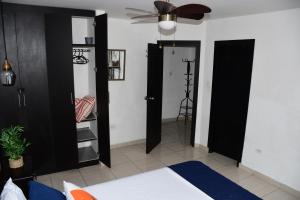通苏帕Moderno Apartamento completo 3piscinas 2jacuzzi y Playa cerca的一间卧室，黑色门，带吊扇