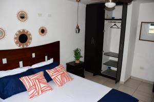通苏帕Moderno Apartamento completo 3piscinas 2jacuzzi y Playa cerca的一间卧室配有蓝色和红色枕头的床