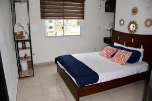 通苏帕Moderno Apartamento completo 3piscinas 2jacuzzi y Playa cerca的一间卧室，配有一张床、两个枕头和一扇窗户 更多27张照片