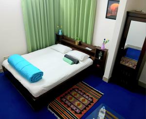 达卡The Blissful Heaven Dhaka的一间卧室，床上有一个蓝色枕头