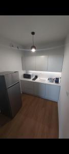 a white kitchen with a sink and a refrigerator at Apartament PRIME Self check-in in Rzeszów +10 photos