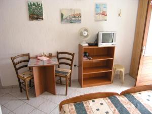 Zimmer mit einem Bett und einem Schreibtisch mit einem TV in der Unterkunft Apartmani Plach in Krk