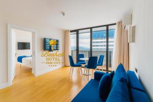 a hotel room with a blue couch and a bedroom at Beach Hotel Orbi City in Batumi