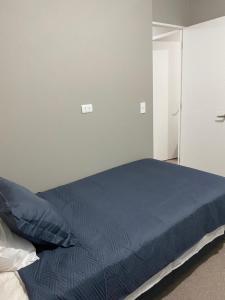 una camera da letto con un letto con un piumone blu di Hospedaje curauma a Lago Peñuelas