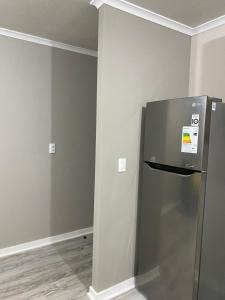 una cucina con un frigorifero in acciaio inossidabile in una stanza di Hospedaje curauma a Lago Peñuelas