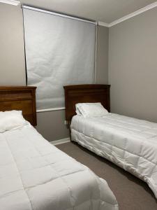 due letti uno accanto all'altro in una camera da letto di Hospedaje curauma a Lago Peñuelas