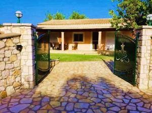 a house with a gate and a stone driveway at Villa Spiti Ute in Makrádes