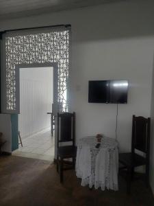 een eetkamer met een tafel en een televisie aan de muur bij Casa 167 in Diamantina