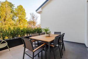Un patio con una mesa y sillas de madera. en Rivazza Apartment - Free WiFi, Air Conditioning & Private Parking, en Imola