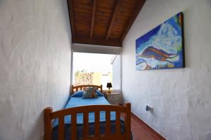 een slaapkamer met een bed en een schilderij aan de muur bij Book Jet - Villa Malpai with private pool jacuzzi in Roque