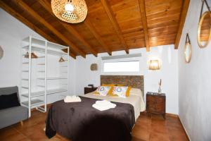 een slaapkamer met een bed en een houten plafond bij Book Jet - Villa Malpai with private pool jacuzzi in Roque +15 foto's