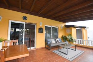 een woonkamer met een bank en een tafel op een balkon bij Book Jet - Villa Malpai with private pool jacuzzi in Roque