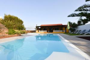 een zwembad voor een huis bij Book Jet - Villa Malpai with private pool jacuzzi in Roque