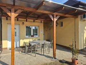a patio with a table and chairs under a pergola at Emma Apartman in Vecsés +11 photos