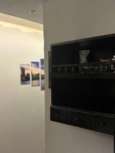 Un armario negro en una pared con dos cuadros. en Quiet & Fully Equipped Private Room, New Cairo, en New cairo