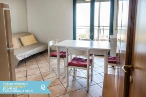 a white table and chairs in a room with a window at Appartamento a Senigallia sul mare - SE004 in Senigallia