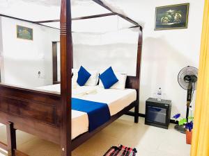 哈伯勒内Hotel Oleena的一间卧室配有一张带蓝色枕头的天蓬床