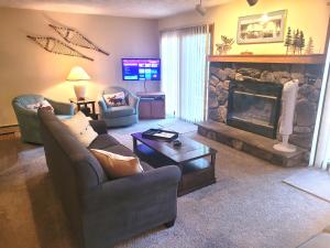 a living room with a couch and a fireplace at New! Crystal Pines - Lovely Crystal Mountain Cabin in Thompsonville