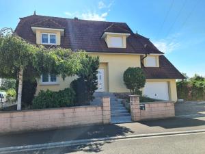 a yellow house with a brown roof at Ma Vie'La - Swimming Pool - Balneo - Jacuzzi - Sauna in Rhinau