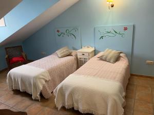 two beds in a room with blue walls at Vista Bella Segovia in Tizneros