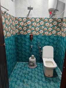 ein kleines Badezimmer mit Toilette und Blumentapete in der Unterkunft BMR home stay inn in Srikalahasti