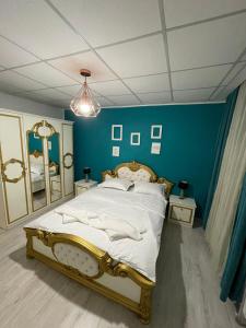 a bedroom with a large bed with a blue wall at Pensiunea Canciu in Craiova
