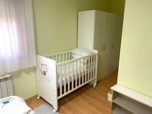 Apartamento del Rosario في كوريلا: غرفة طفل مع سرير أطفال وخزانة