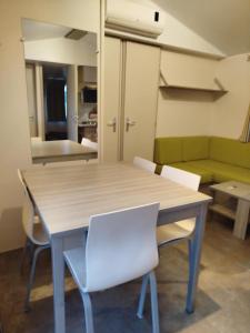 un tavolo e delle sedie in una stanza con un divano di Mobil-home 6 places dans camping 4 étoiles a Lit-et-Mixe
