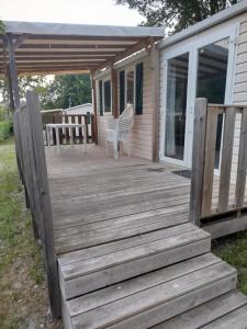 una terrazza in legno con una sedia su una casa di Mobil-home 6 places dans camping 4 étoiles a Lit-et-Mixe