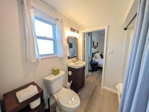 ein Badezimmer mit Toilette und Waschbecken und einem Fenster in der Unterkunft Modern Norwalk Retreat with 2 King Suites in Norwalk