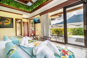 福尔图纳阿雷纳尔温泉度假村酒店的一间带两张床和阳台的卧室