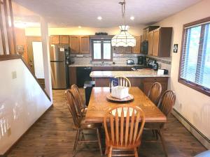a kitchen with a wooden table and chairs and a refrigerator at New! Crystal Pines - Lovely Crystal Mountain Cabin in Thompsonville