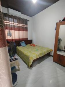 Preethi Villa في Nikawatawana: غرفة نوم صغيرة مع سرير ومرآة