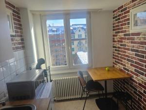 a small kitchen with a table and a window at Central studio apartment stgallen gratis Parkplatz in St. Gallen