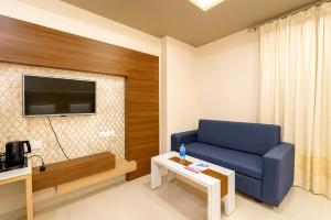 a living room with a blue couch and a table at Rooftop Sea View the KP Palace Near Jaganath temple - Restaurant # Lift and Free Parking Facilities # Fully Air Conditioning Hotel - Luxuary Hotel Prime Location in Puri