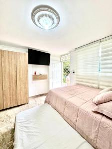 a bedroom with a large bed and a ceiling at Acogedor studio frente al parque - Cerca de todo in Floridablanca