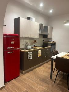 La Dimora di Bacco في Sannicandro di Bari: مطبخ مع ثلاجة حمراء وطاولة