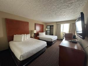 梅迪辛哈特Wyndham Garden Medicine Hat Conference Center的一间配有两张床和一台平板电视的酒店房间