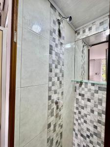 a bathroom with a shower with a glass door at Acogedor studio frente al parque - Cerca de todo in Floridablanca