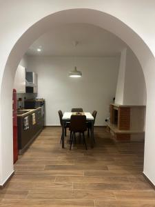 La Dimora di Bacco في Sannicandro di Bari: مطبخ وغرفة طعام مع طاولة وكراسي