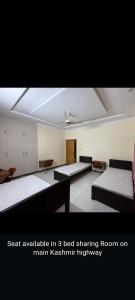 ein Zimmer mit drei Betten und einer Decke in der Unterkunft Professional lodges in Islamabad