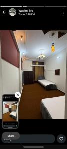 ein Bild von einem Zimmer mit zwei Betten und einem Telefon in der Unterkunft Professional lodges in Islamabad