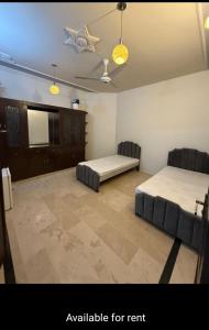 Zimmer mit 2 Betten und 2 Stühlen in der Unterkunft Professional lodges in Islamabad