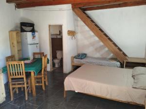 a small room with a bed and a table and chairs at La morocha in Camba Punta