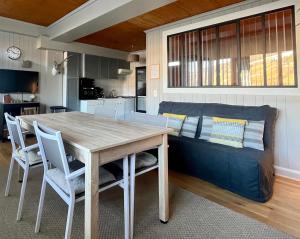 a kitchen and dining room with a table and a couch at White Lodges - Megève center on ski slopes in Megève +8 photos