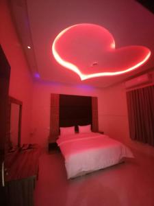 ハーイルにあるروعة أجا للشقق المخدومة غرفة وصالةの天井にハートのマークが描かれたベッドのある寝室