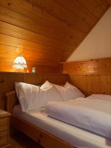 two beds in a room with a wooden ceiling at Ferienhaus s'Mosern in Grundlsee