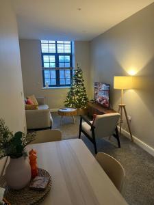 a living room with a christmas tree in the corner at Chic Mill conversion beside Piece Hall & Eureka! in Halifax +4 photos