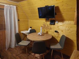 a dining room with a table and chairs and a tv at Mókuslak Mátra in Mátraszentimre
